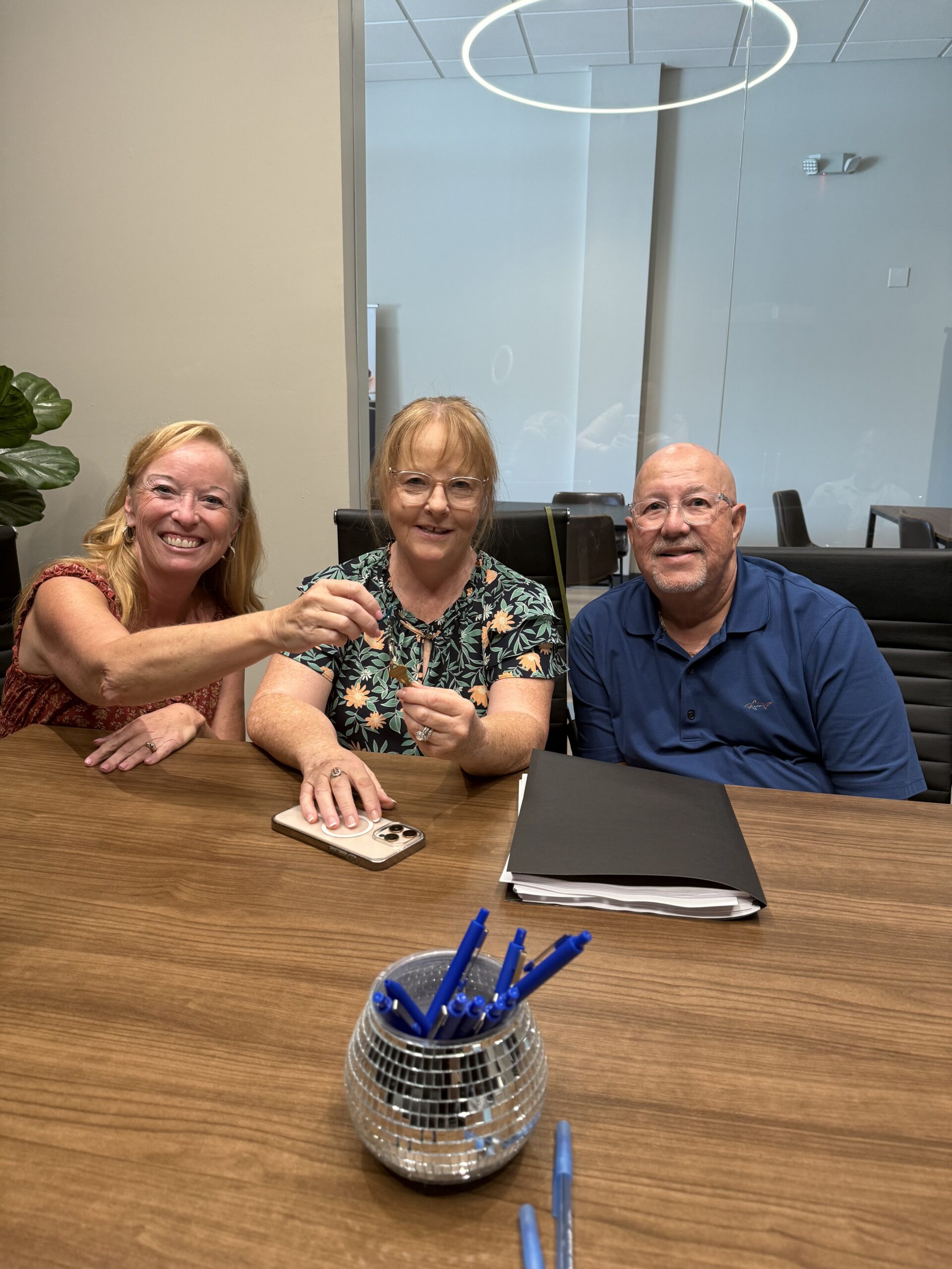 Carey and Clients are holding up their new key to their new house