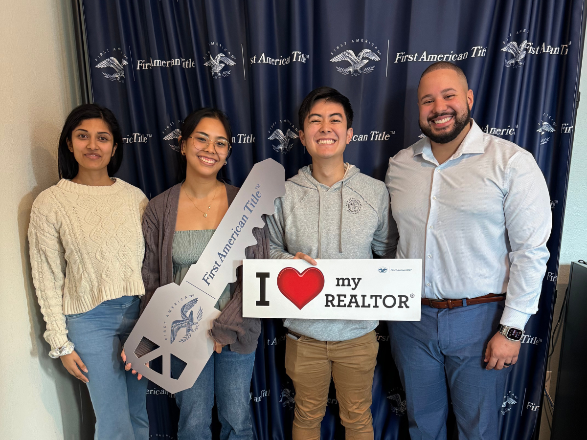 alvin abud (right) with 3 clients at closing smiling. holding a hey and a sign that says I love my realtor