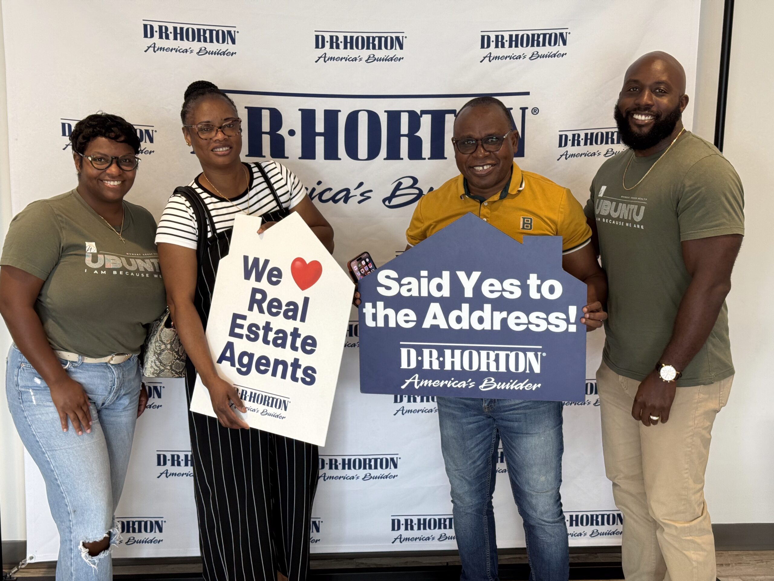 Kelly Reid Team with Happy Clients at Closing Day Smiling Kelly Reid Team with Happy Clients holding House shaped signs on closing day