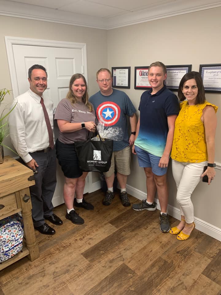 Corey with client's family at closing smiling 