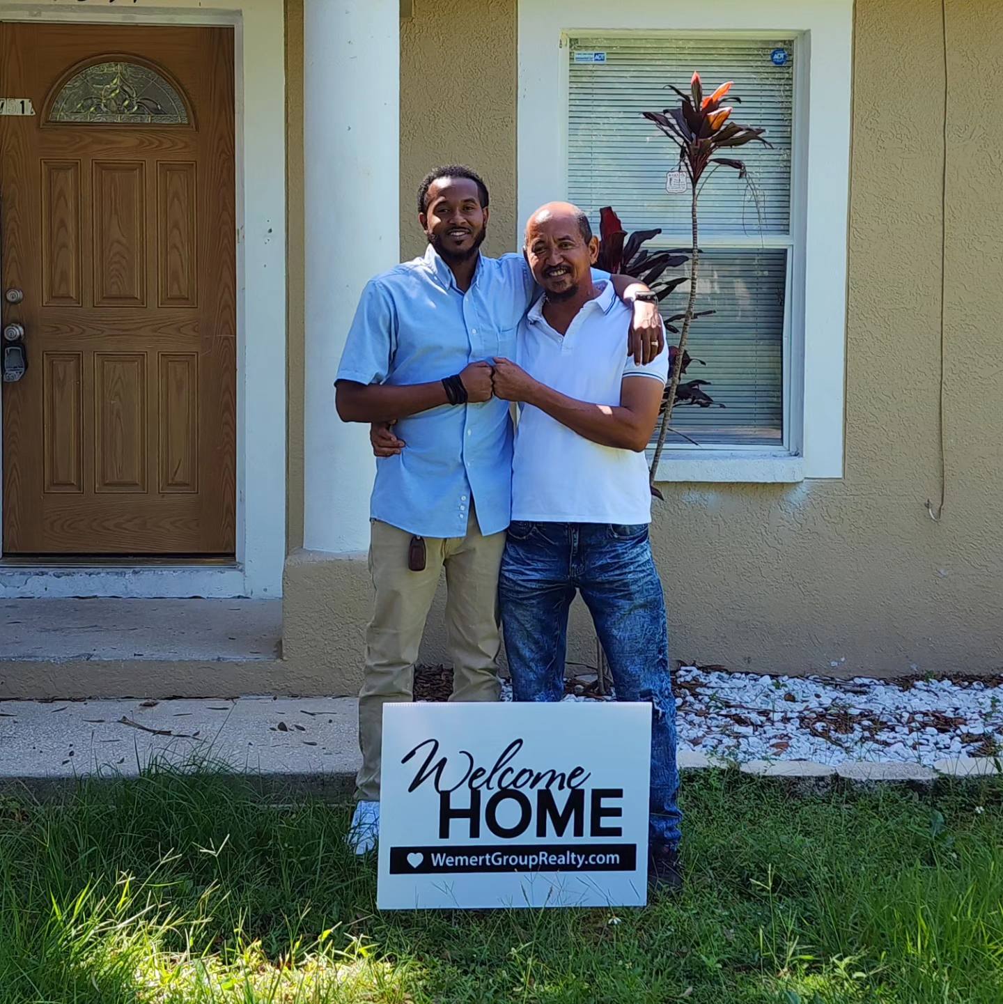 buy a home; this picture is two buyers looking happy in front of their new home